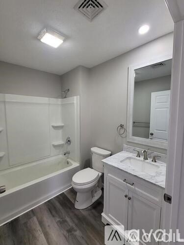 A white bathroom with a toilet, sink, and bathtub.