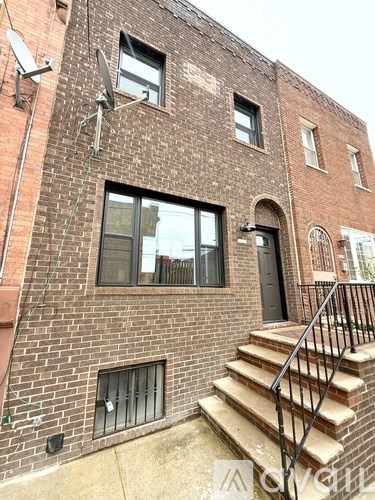 A brick building with a staircase leading to the door.