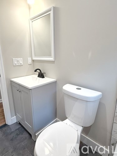 A white toilet sits next to a sink in a bathroom.