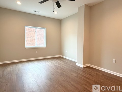 A room with a ceiling fan and a window with blinds.