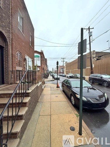 A black car is parked on the side of a street.