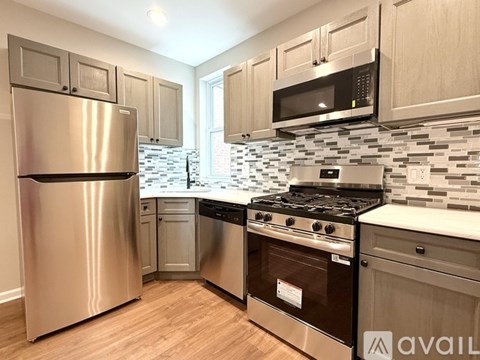 A kitchen with a stainless steel refrigerator, oven, and microwave.