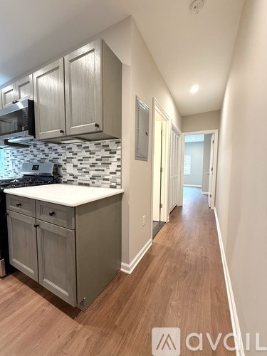 A kitchen with wooden floors and a tiled backsplash.