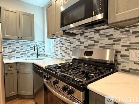 A kitchen with a stove, microwave, and cabinets.