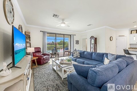 A living room with a blue couch and a flat screen TV.