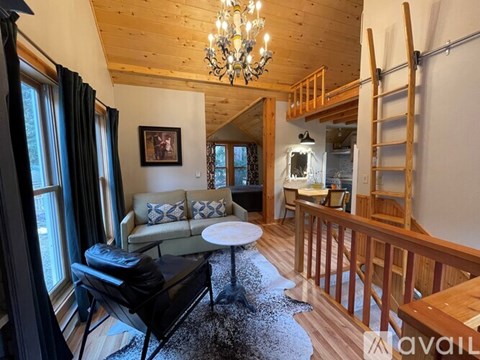 A living room with a couch, chairs, and a chandelier.