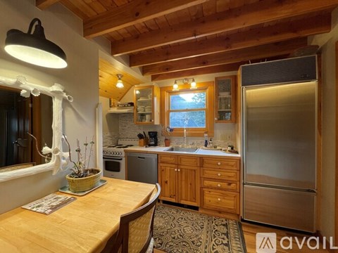 A kitchen with wooden cabinets and a refrigerator.