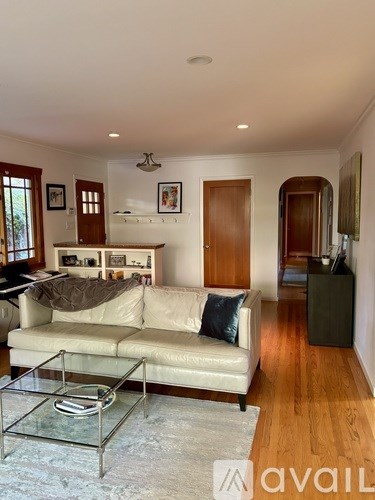 A living room with a beige couch and a glass coffee table.