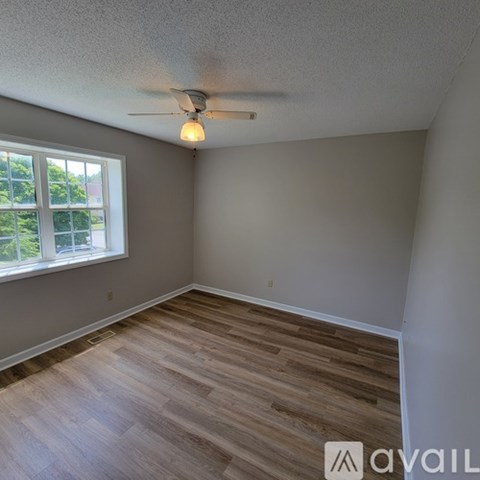 A room with a ceiling fan and a window.
