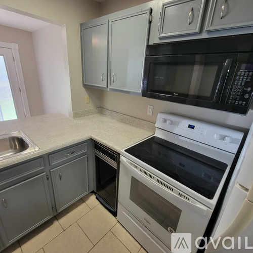 A kitchen with a white oven and microwave.