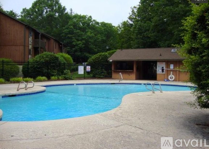 A pool with a slide and a building behind it.