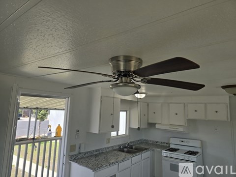 A kitchen with a fan and a stove top oven.