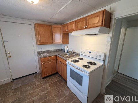 A kitchen with white appliances and wooden cabinets.