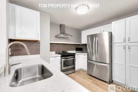A kitchen with white cabinets and stainless steel appliances.