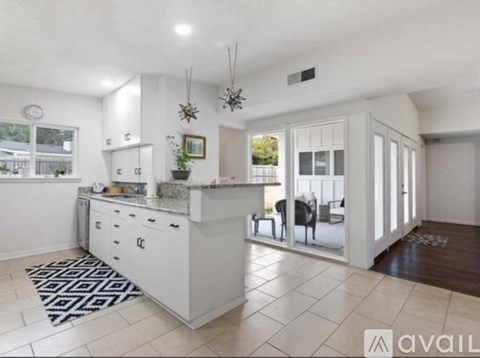A modern kitchen with white cabinets and a large island.