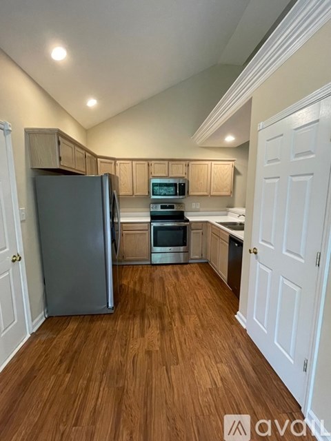 A kitchen with wooden floors and white walls.