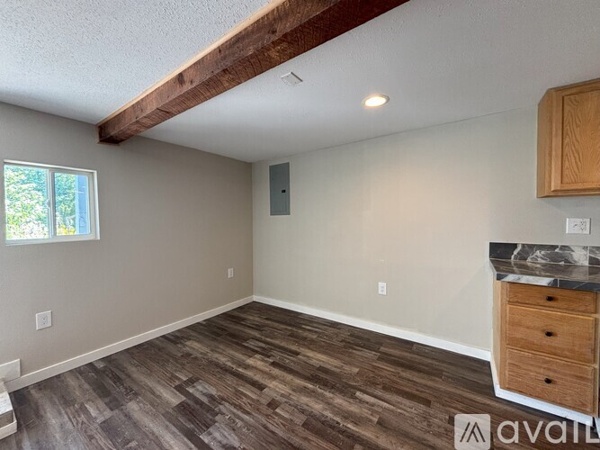 A room with wooden flooring and a window.