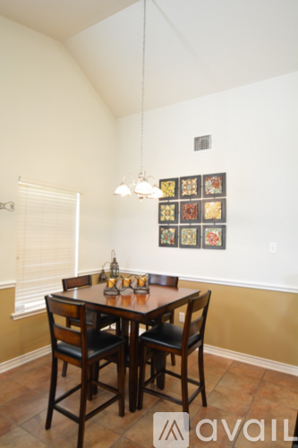 A dining room with a table and chairs.