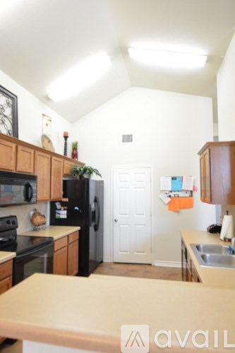 A kitchen with wooden cabinets and black appliances.