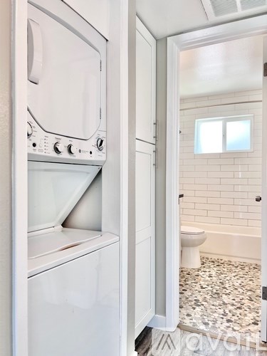 A white oven and a white toilet in a bathroom.