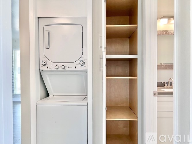 A white dishwasher is open, revealing its empty shelves.