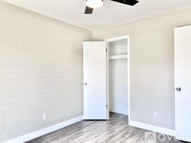 A white door is open in a room with a brick wall.