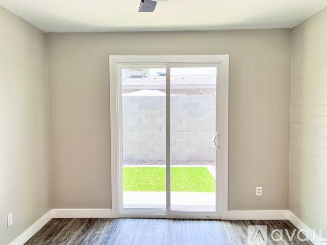 A room with a sliding glass door leading to a backyard.