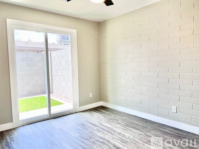 A room with a white brick wall and a sliding glass door.