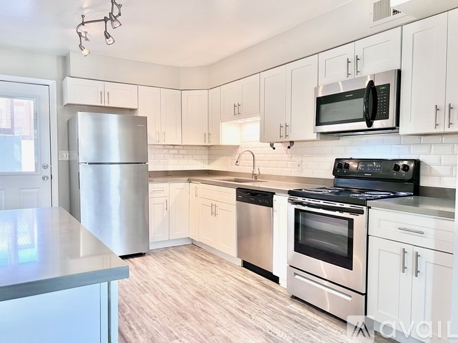 A kitchen with white cabinets and stainless steel appliances.