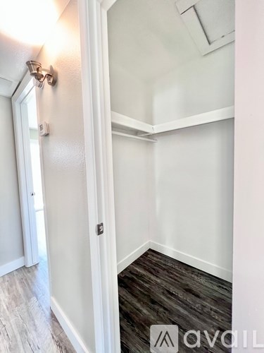 A hallway with a white door and a wooden floor.