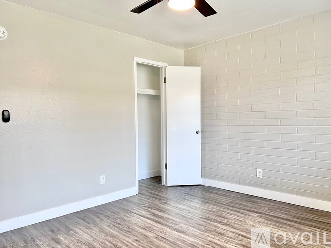 A room with a white door and a ceiling fan.