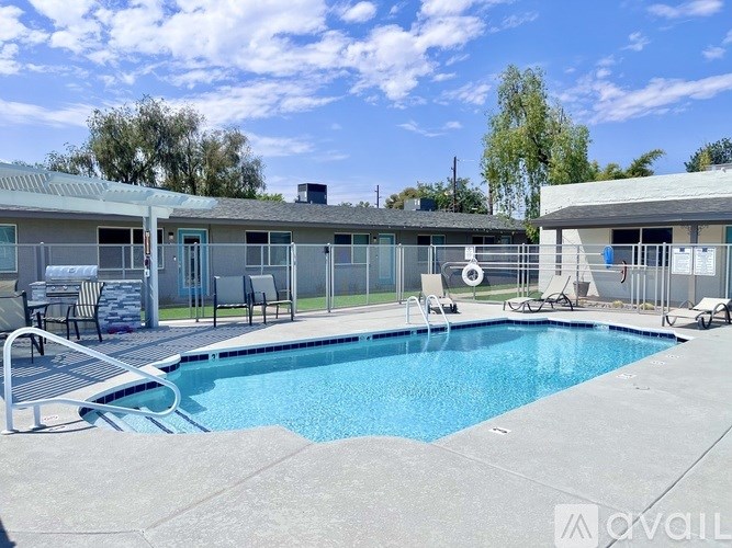 A swimming pool in front of a house with a sun lounger.