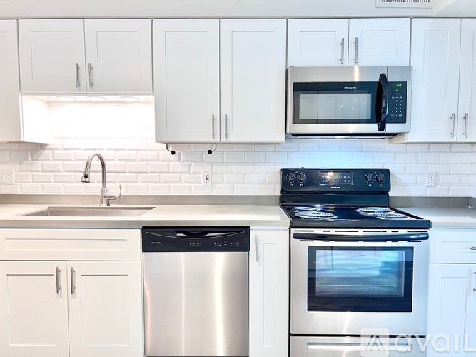 A modern kitchen with white cabinets and stainless steel appliances.
