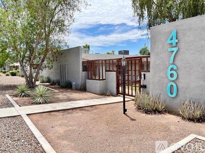 A modern house with a concrete wall and a number 4760 on it.