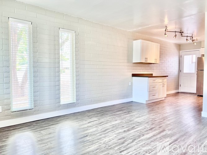 A white room with wooden floors and a window.
