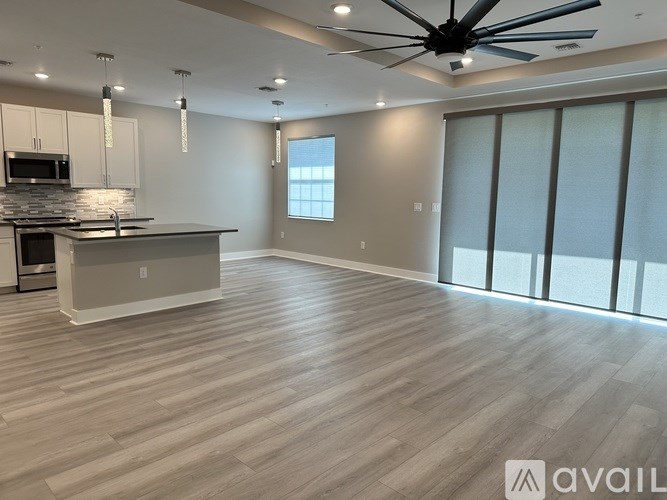 A spacious kitchen with a fan on the ceiling and a dining area with a table and chairs.