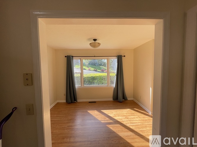 A room with a view of a road through the window.