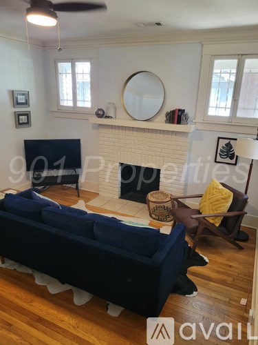 A living room with a blue couch and a fireplace.