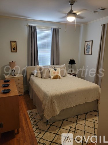 A bedroom with a bed, dresser, and ceiling fan.