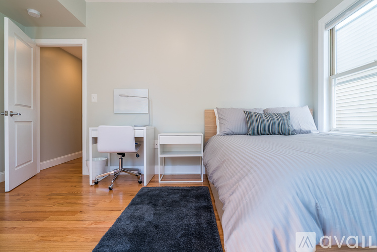 A bedroom with a bed, desk, and chair.