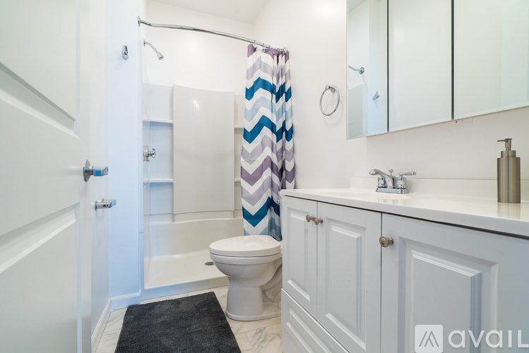 A bathroom with a toilet, sink, and shower.