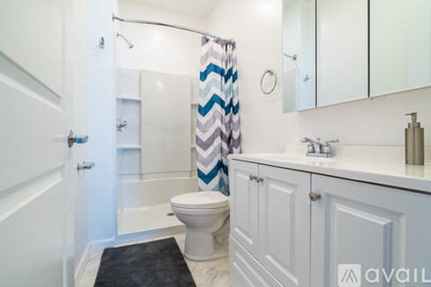 A bathroom with a toilet, sink, and shower.
