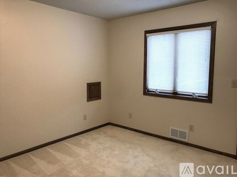 A room with a window and a picture frame on the wall.