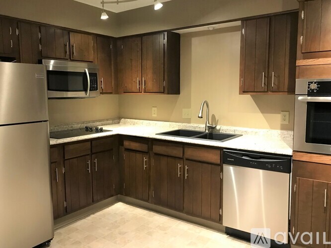 A kitchen with wooden cabinets and stainless steel appliances.