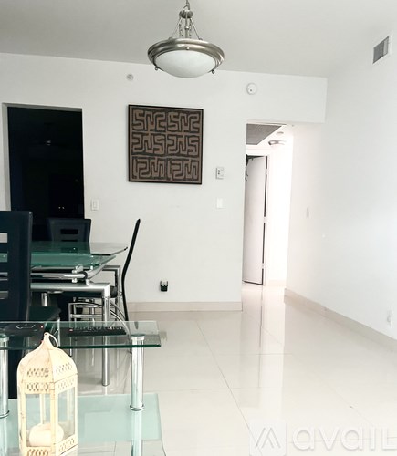 A modern dining room with a glass table and chairs.