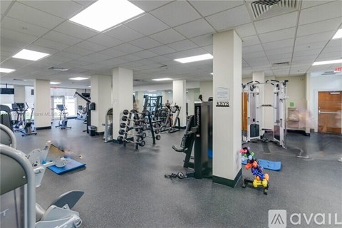 A gym with a variety of equipment including treadmills, weights, and exercise machines.