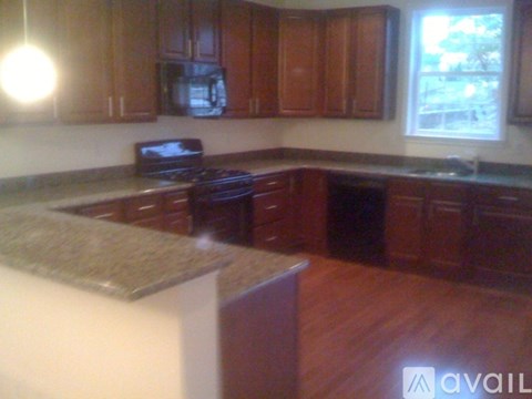 A kitchen with brown cabinets and a granite counter.