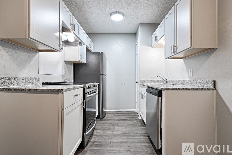 A kitchen with white appliances and beige cabinets.