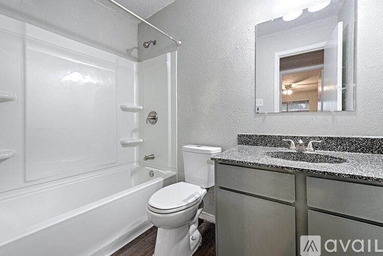 A bathroom with a white toilet and a white bathtub.