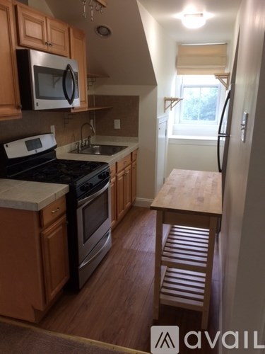 A kitchen with wooden cabinets and a stove top oven.